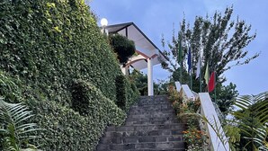 A set of stone steps leading up to a building, surrounded by lush greenery and potted plants. - Mirabel Resort (Dhulikhel)