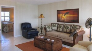 A living room with a sofa, armchairs, a coffee table, and a painting on the wall. - Riverside B407 (Marco Island)