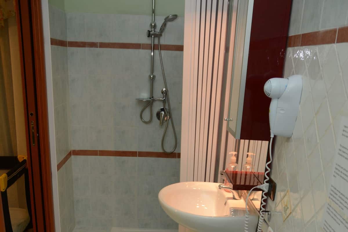 Un baño con ducha, lavabo, bidé e inodoro.