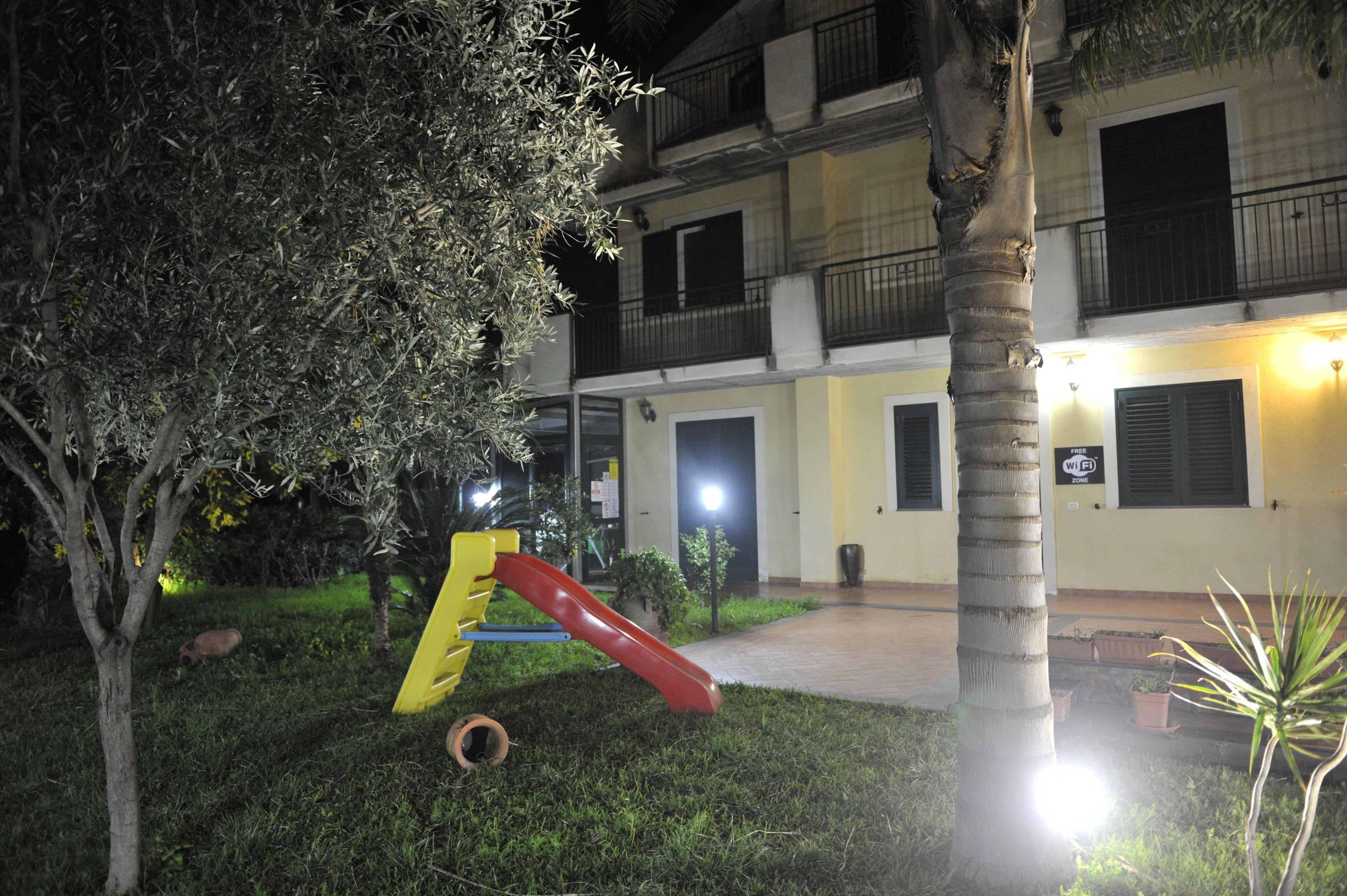 Vista frontal de la propiedad por la tarde o noche