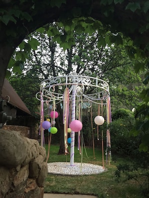 A garden with a decorative metal gazebo featuring hanging paper lanterns. - Rainforest Boutique Camp (Krugersdorp)
