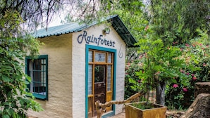 A small building with a sign reading "Rainforest" and a wooden door with the number 57. - Rainforest Boutique Camp (Krugersdorp)