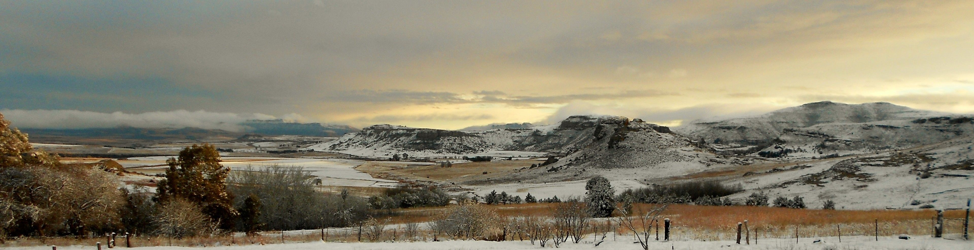 A snowy landscape with mountains and a valley.