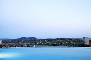 Een buitenzwembad, parasols voor strand/zwembad