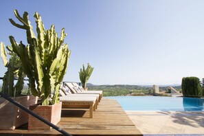 A wooden deck with lounge chairs and a pool. - Can Cota Suites & Spa - Turismo de interior (Selva)