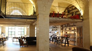 A spacious library with high ceilings, bookshelves, and a mezzanine level.