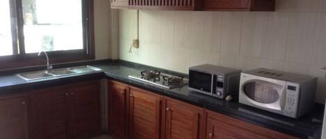A kitchen with wooden cabinets, a microwave, and a gas stove.