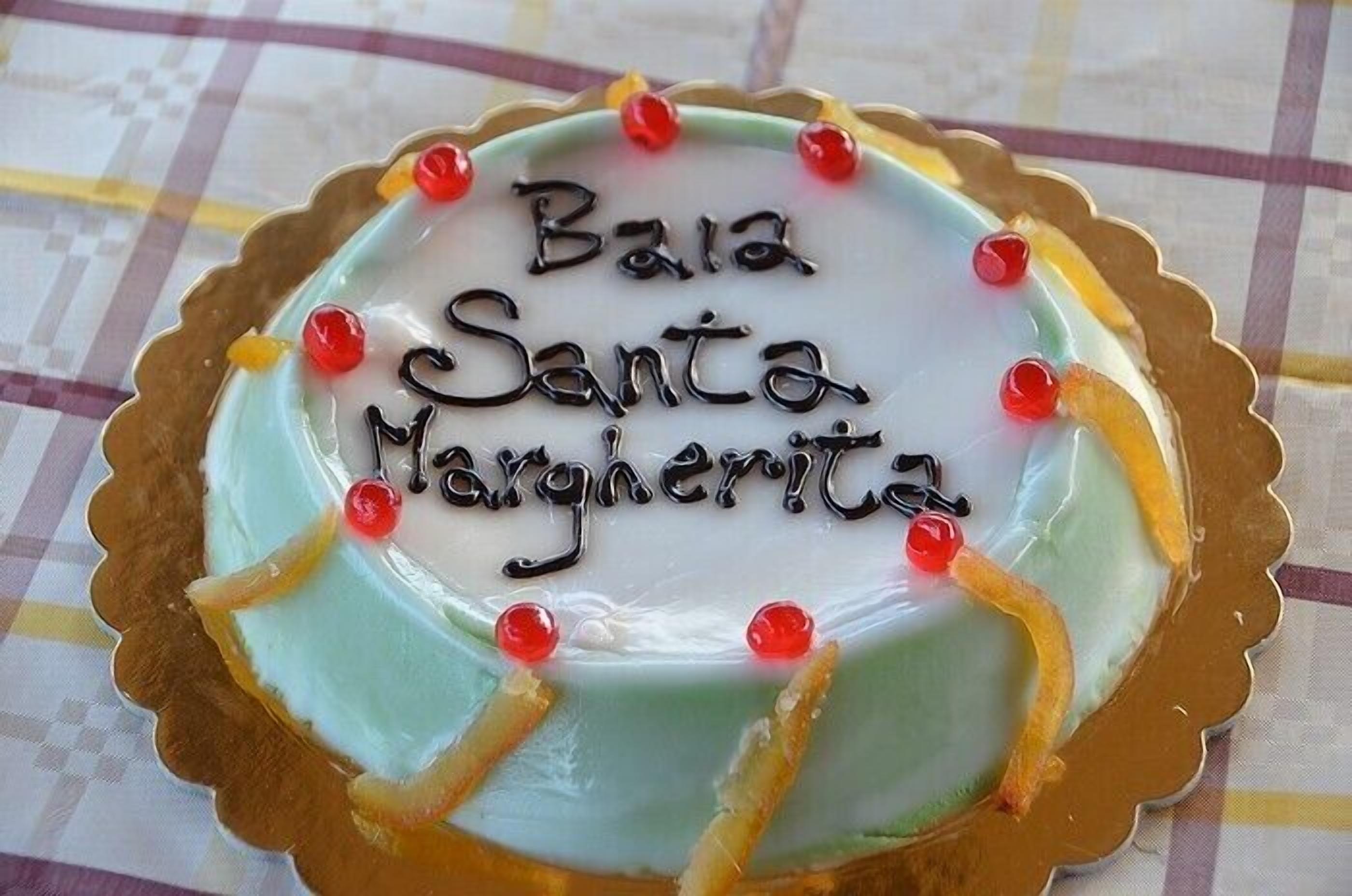 Ein Kuchen mit der Aufschrift "Bara Santa Margaritita" und dekorativen Elementen.
