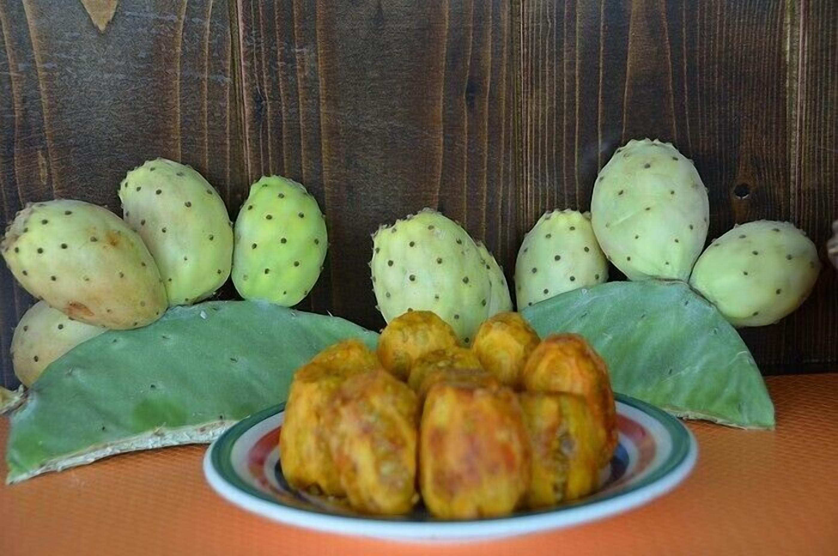 Um prato de comida com várias frutas verdes e uma folha verde.