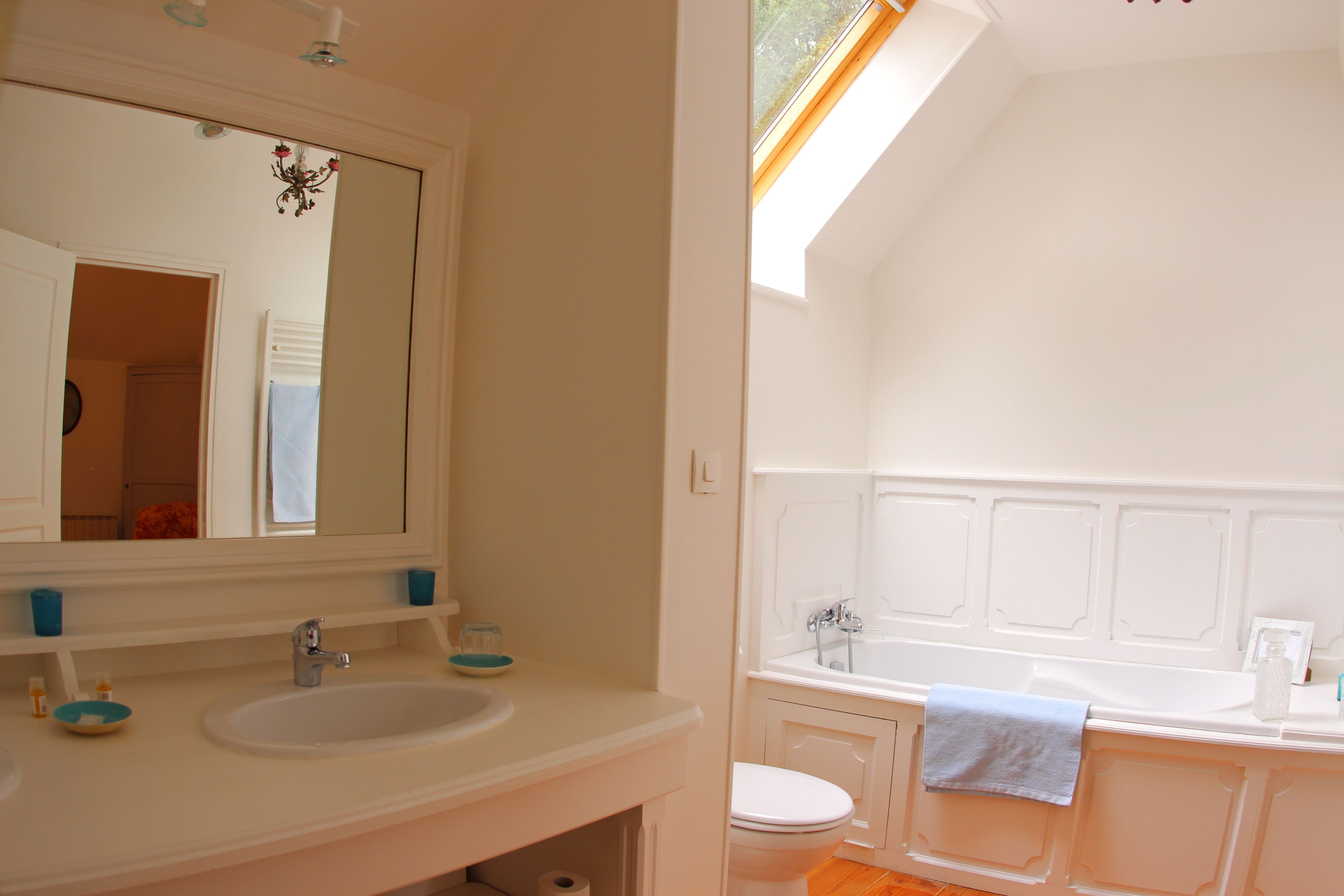 A bathroom with a sink, mirror, and bathtub.