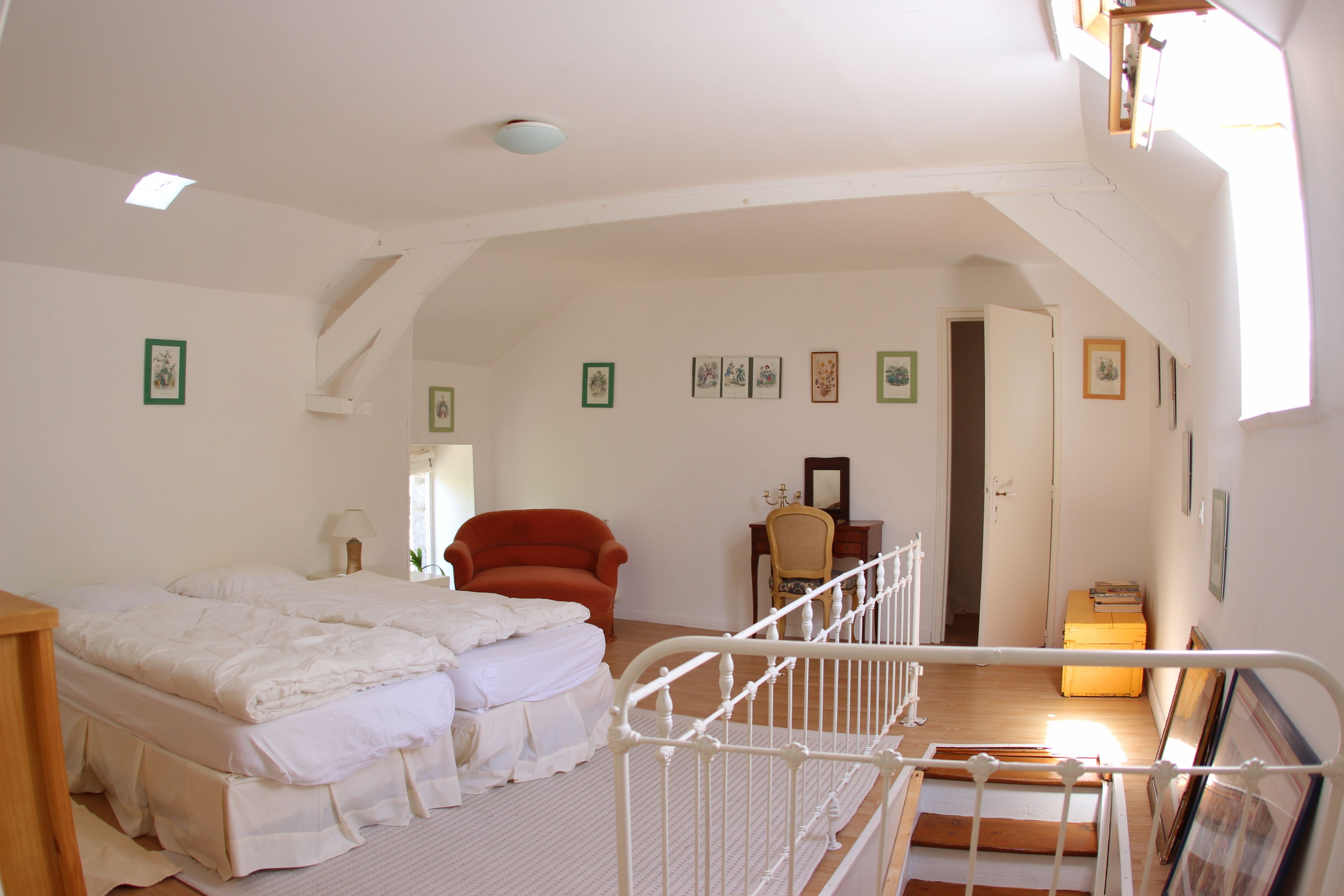 Une chambre à coucher avec un lit, une chaise, un bureau et une fenêtre.