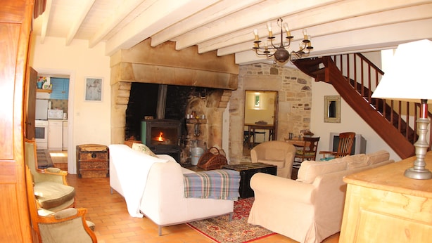 Un salon chaleureux avec une cheminée, des meubles en bois et un escalier.