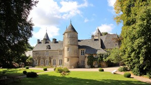 Un grand bâtiment historique doté de nombreuses tours et d’un jardin bien entretenu.