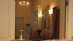 A hotel room with a wooden reception desk, a chandelier, a map, and a mirror. - Hotel Beethoven (Frankfurt)