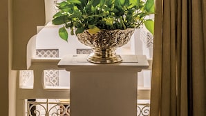 A view through an arched doorway with a potted plant on a balcony. - Dar El Mudal - Adults Only (Marrakech)