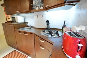 Una cucina con mobili in legno, un forno a microonde, un tostapane e un lavandino.