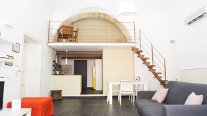 A modern apartment with a loft bedroom, a dining area, and a staircase. - 1743 Loft Siracusa (Syracuse)