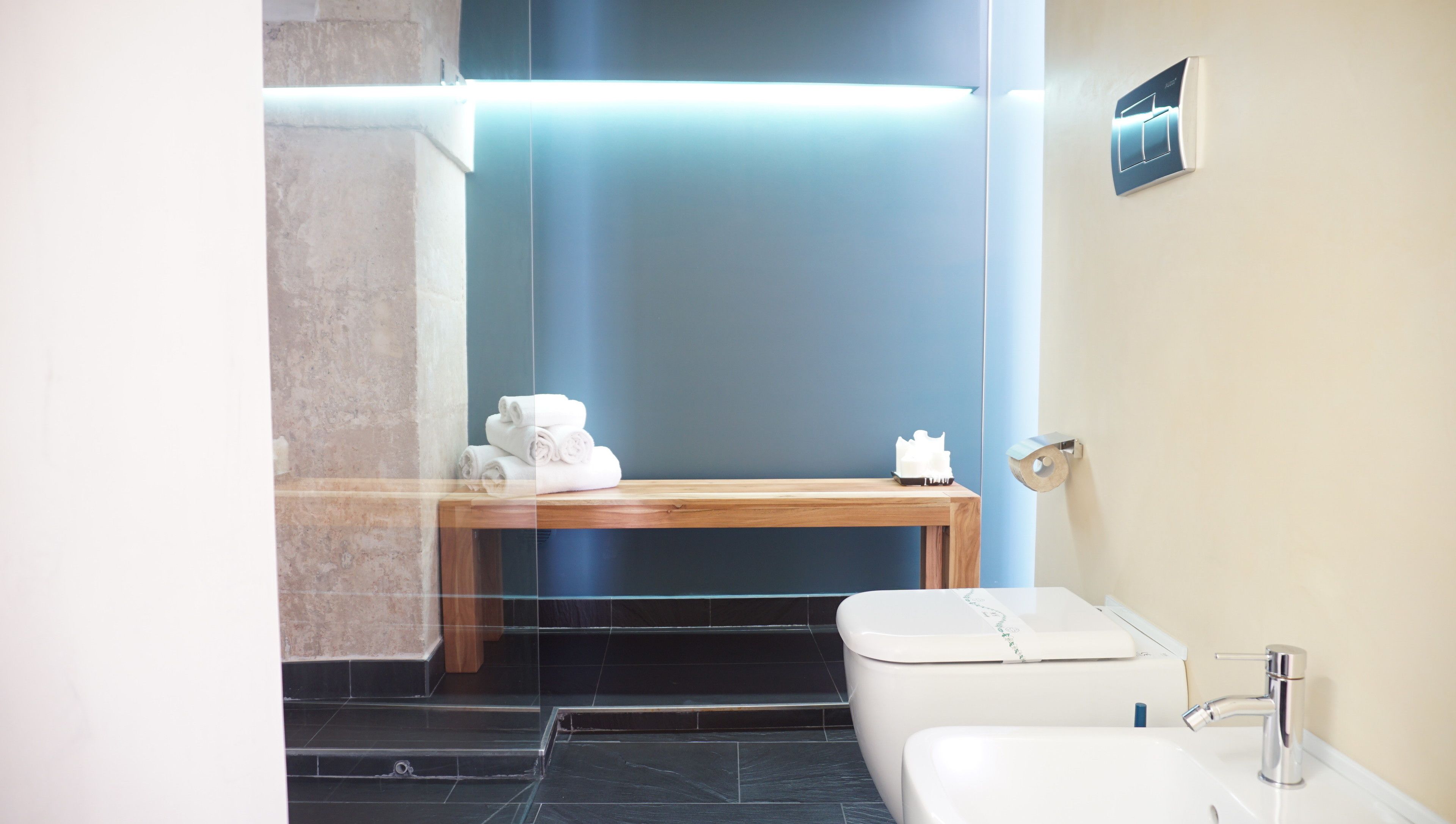 Une salle de bain moderne avec un meuble-lavabo en bois, des toilettes et un lavabo.
