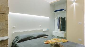 Un dormitorio moderno con cama, armario y mesita de noche.