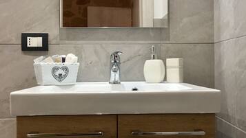 A bathroom with a white sink, a mirror above it, and a wooden cabinet below.
