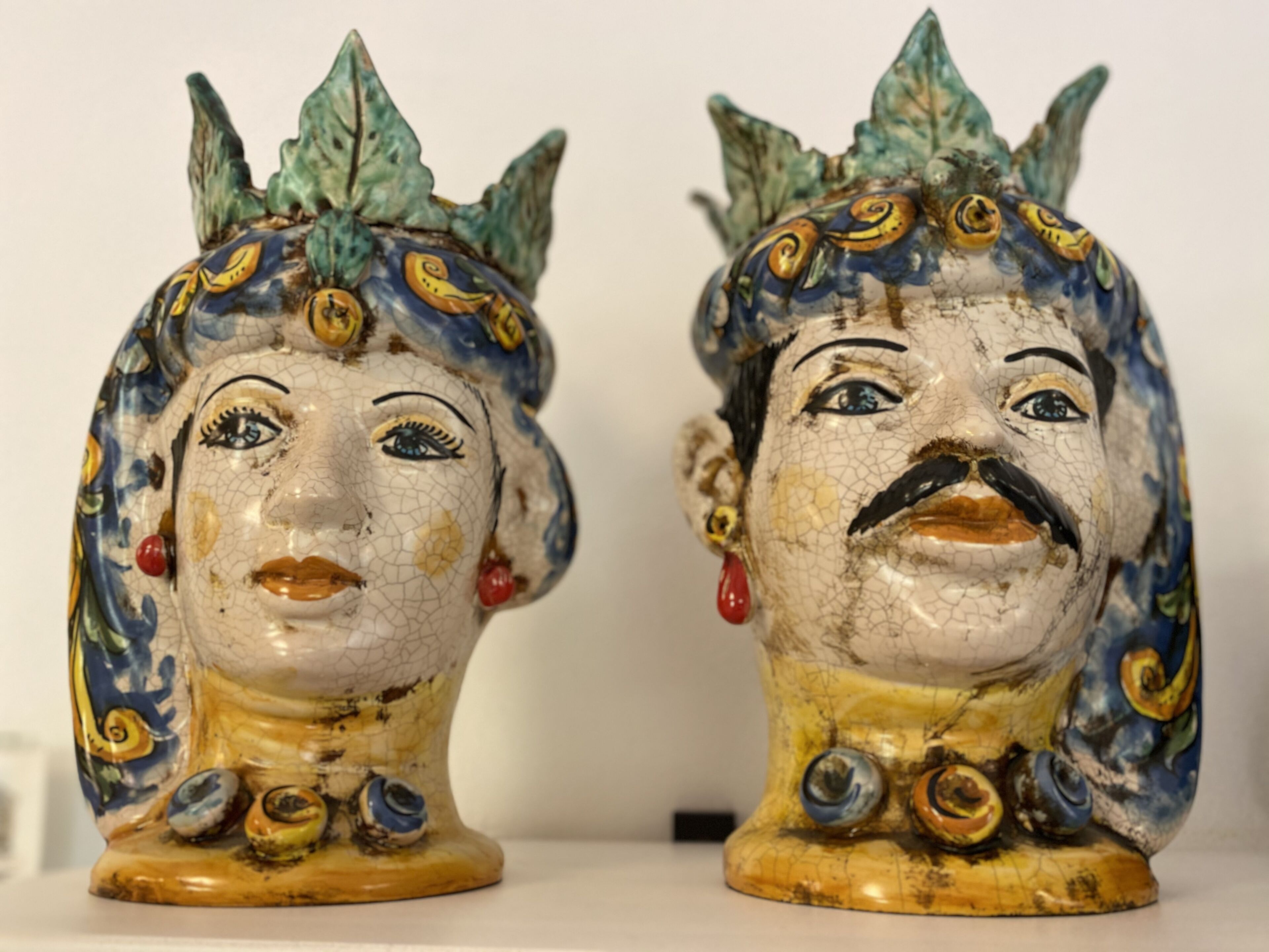 Two ceramic figurines with intricate designs and facial features.