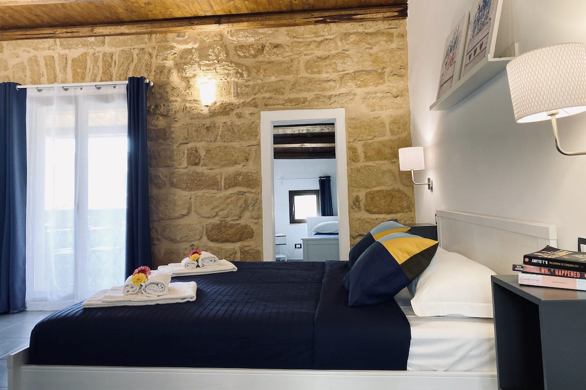 Habitación triple Deluxe, terraza, vistas al jardín | Ropa de cama hipoalergénica, edredones de plumas, minibar y escritorio