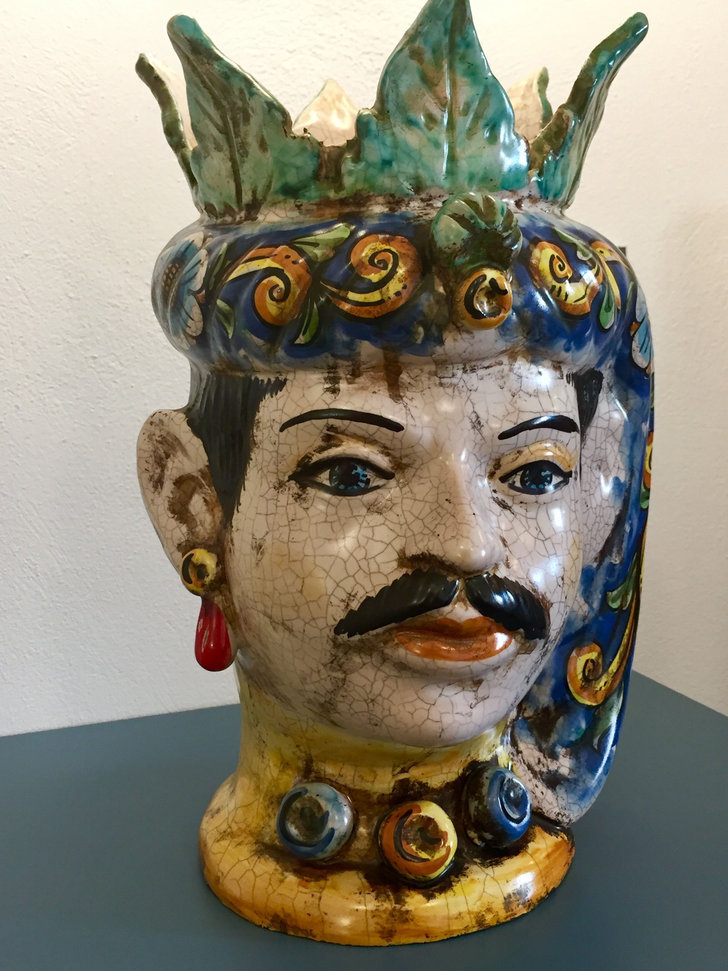 Un pot en céramique dont la surface est craquelée et ornée de motifs colorés.