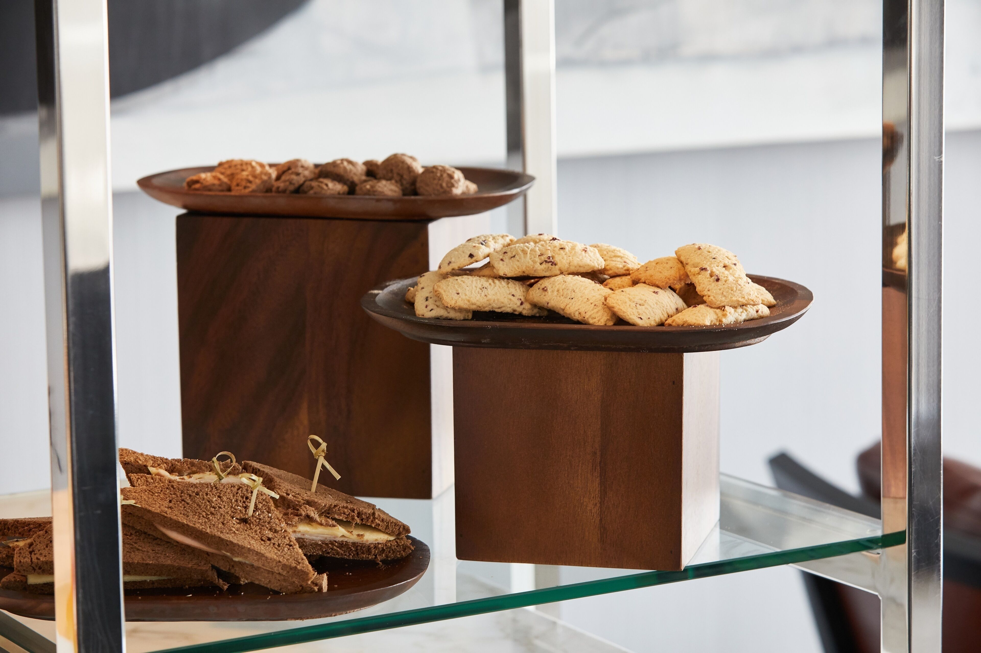 Una mesa de vidrio con una selección de galletas y un sándwich.