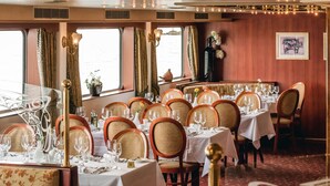 Een restaurantwagon met gedekte tafels, met uitzicht op het water.
