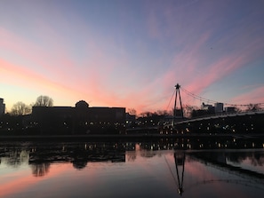 A sunset over a calm river with a bridge and buildings in the background. - KNM MS Switzerland II - Frankfurt (Frankfurt)