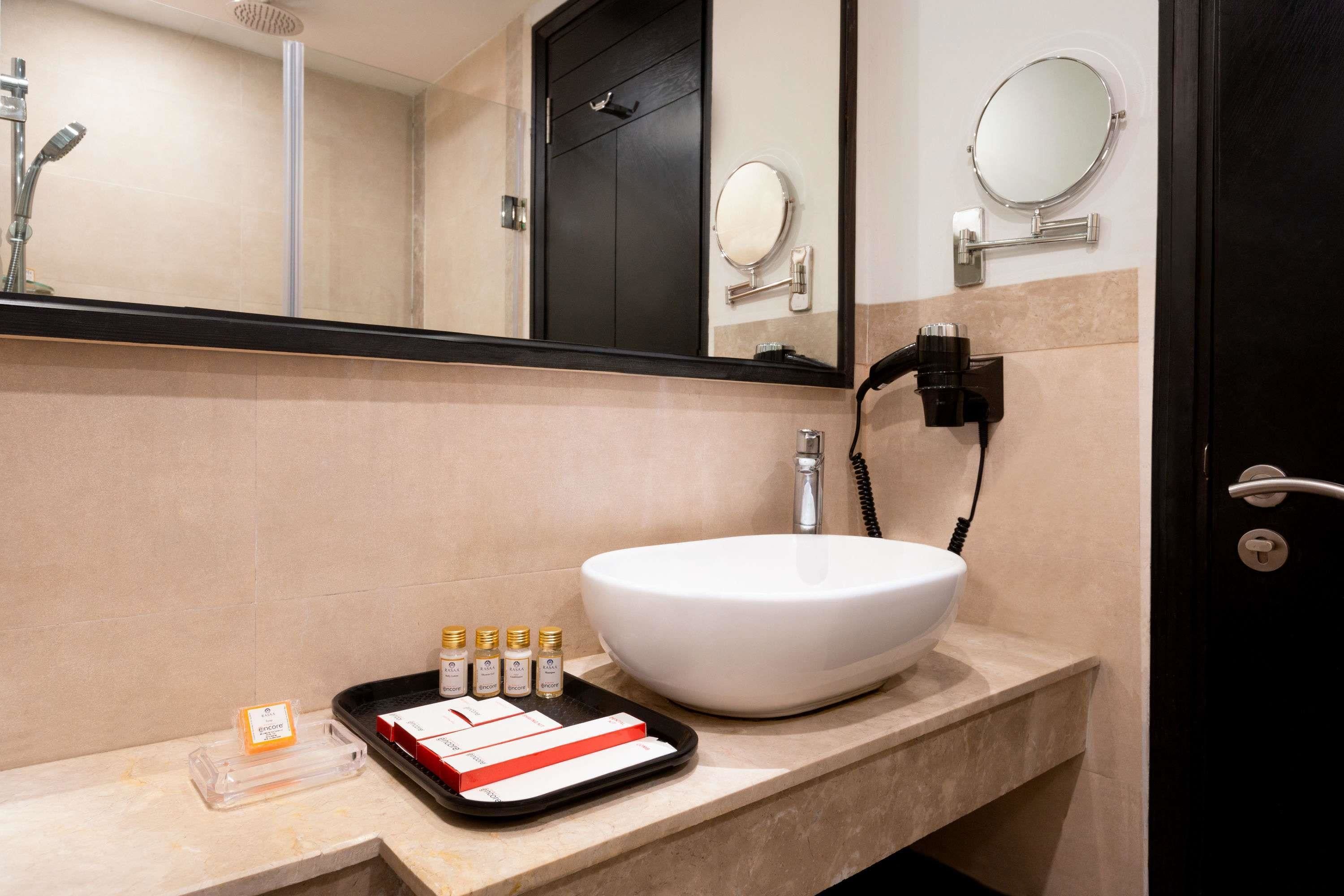 Un baño con un lavabo grande de color blanco, un espejo y una puerta negra.