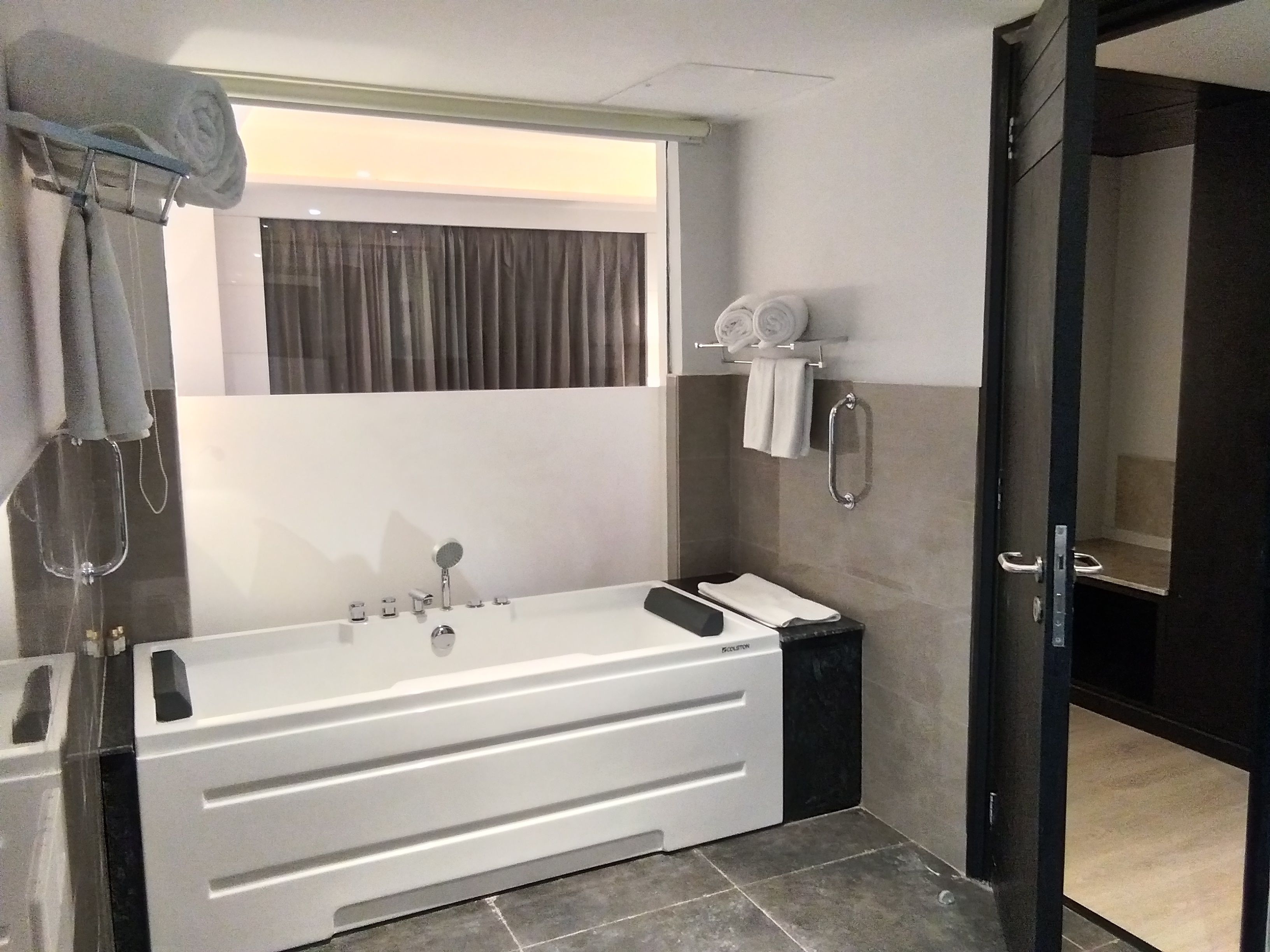 A modern bathroom with a large bathtub, a shower area, and a toilet.