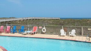 Un espace piscine avec des chaises longues et un panneau indiquant « Il est interdit de plonger ».