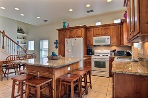 Enjoy cooking in this well-equipped kitchen with an island, gas range, and refrigerator.