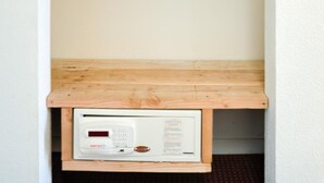 Un petit espace clos, doté d’une étagère en bois et d’un panneau de commande.
