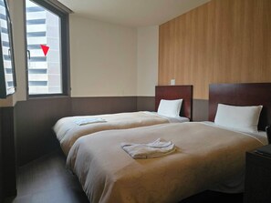 Habitación de hotel con dos camas, cabecera de madera y ventana con persianas.