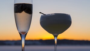 Two glasses of beverages on a surface with a sunset in the background. - Mat-Su Resort (Wasilla)