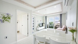 Una sala de estar moderna con un amplio ventanal que da a un balcón.