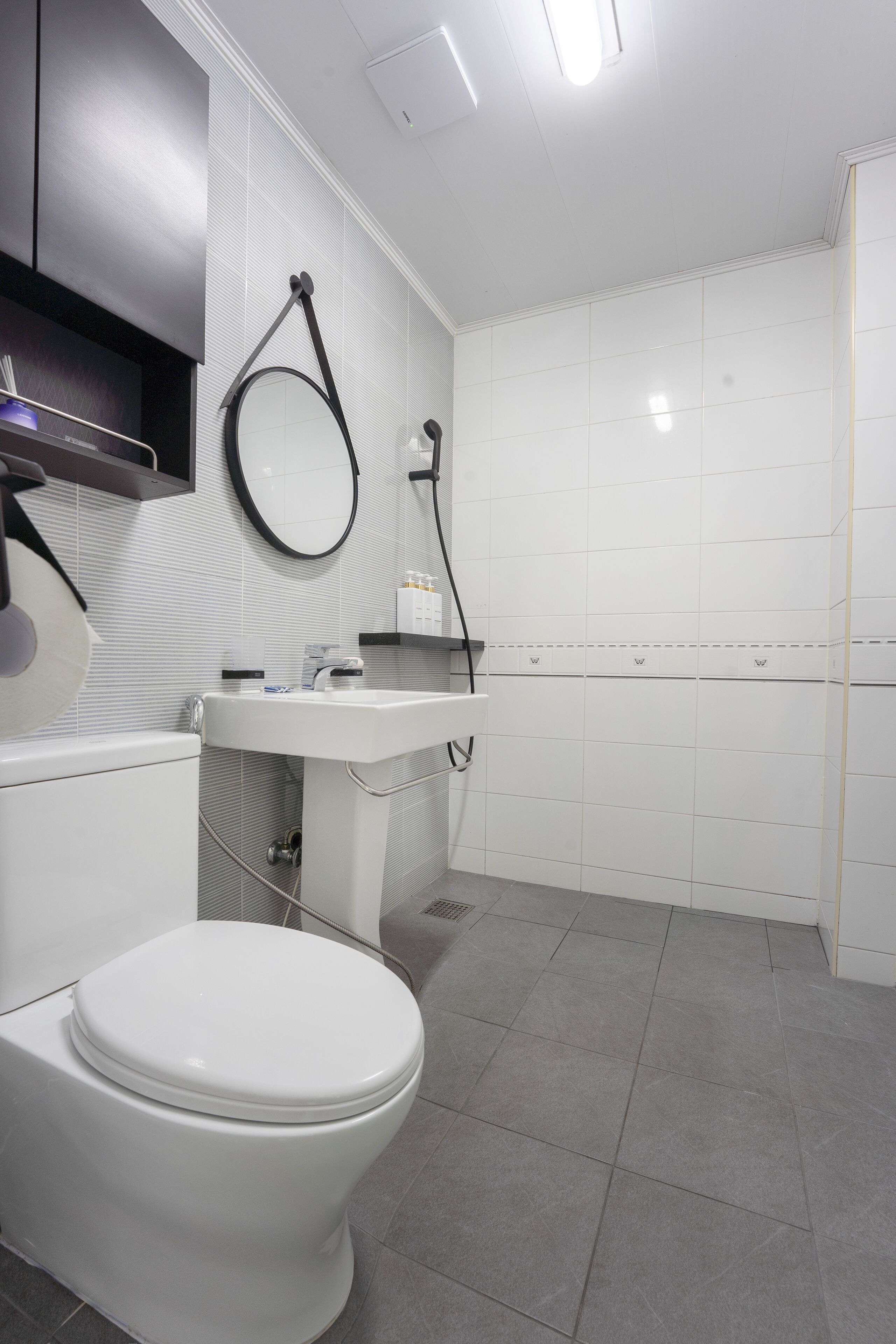 Un baño moderno con inodoro, lavabo y espejo.