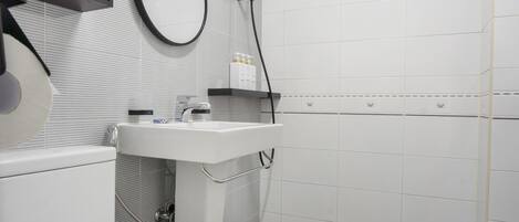 Un baño moderno con inodoro, lavabo y espejo.