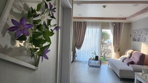Una sala de estar con sofá, una mesa de centro y vistas al exterior.
