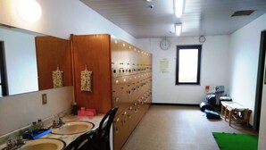 Une salle de bain avec deux lavabos, un miroir, un meuble en bois et un tapis vert sur le sol.