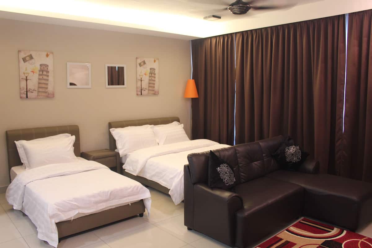 Une chambre d’hôtel avec deux lits, un canapé et un ventilateur de plafond.