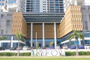Um edifício moderno com fachada única, grandes janelas e uma placa com a inscrição 'TREFON'.