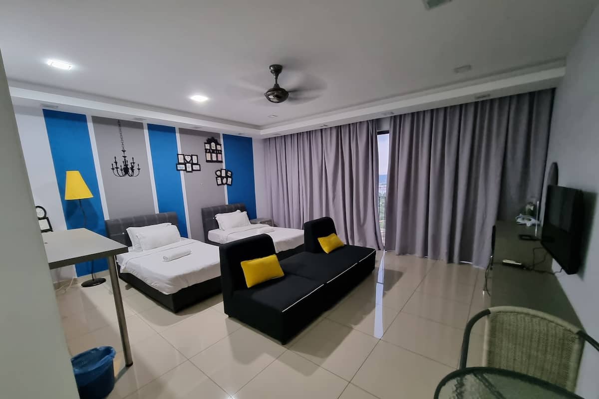 Une chambre d’hôtel moderne avec deux lits, un canapé, une télévision et un balcon avec des rideaux.