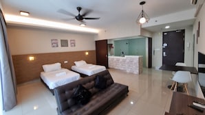 Une chambre d’hôtel moderne équipée de deux lits, d’un canapé, d’un bureau et d’un espace de réception.