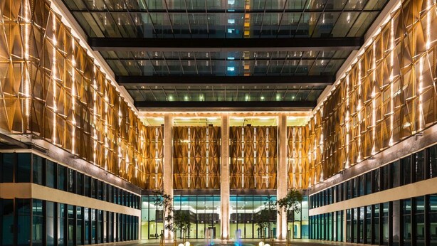 Un hôtel moderne doté d’un plafond en verre orné d’un motif géométrique de jeux de lumière.