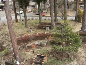 A garden area with various plants, a small tree, and a brick structure. - Friendly Inn People (Fujikawaguchiko)