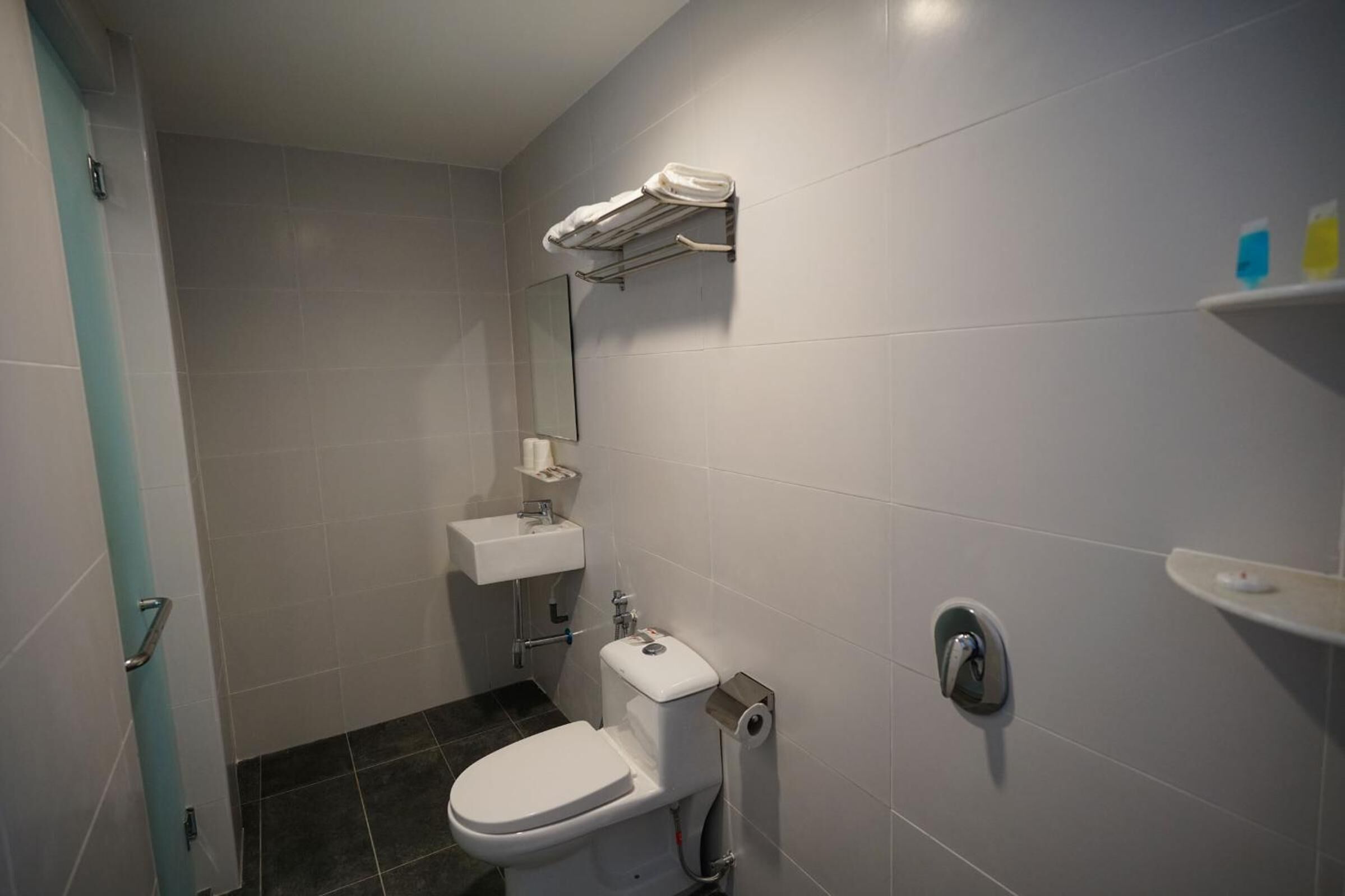 Ein kleines Badezimmer mit Toilette, Waschbecken und Spiegel.