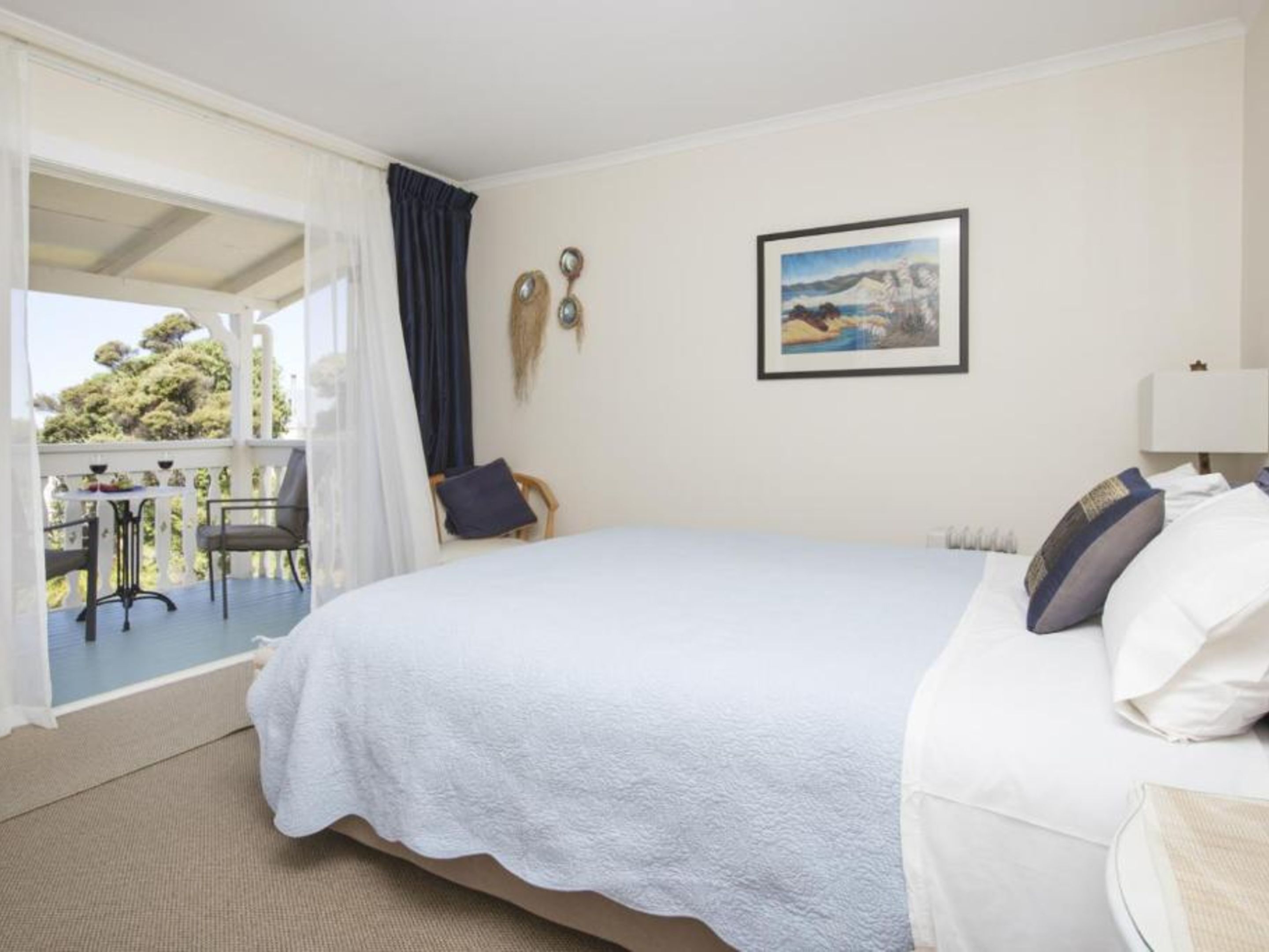 A bedroom with a bed, a desk, and a chair.